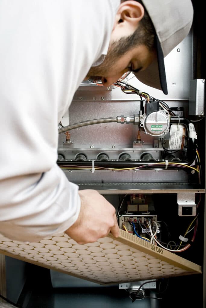 man changing furnace filter in the woodlands, tx